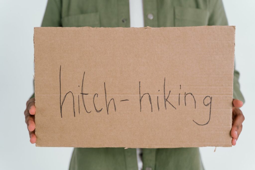13 Best Tips For Hitchhiking (Beginners) Close-up Photo of Hitchhiking Cardboard held by a traveler