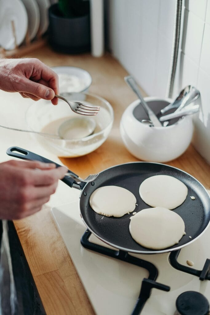 4 Important skills to learn for Solo Traveller a solo traveler preparing pancakes